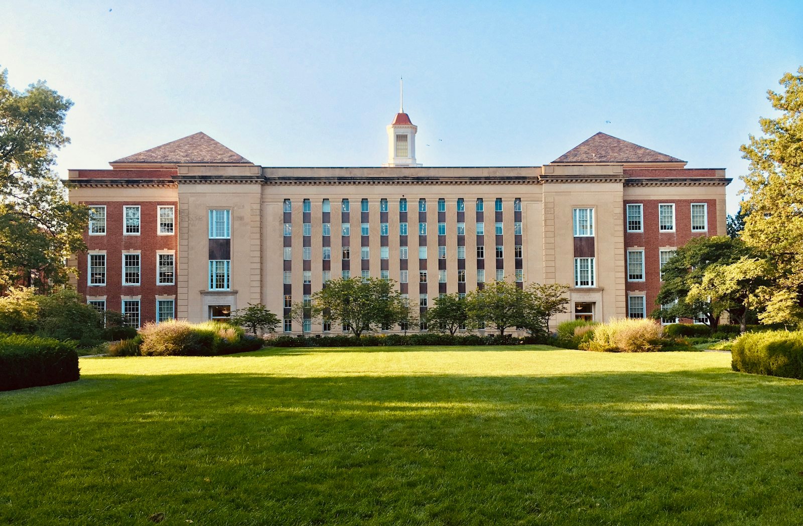 A university campus building with a green lawn