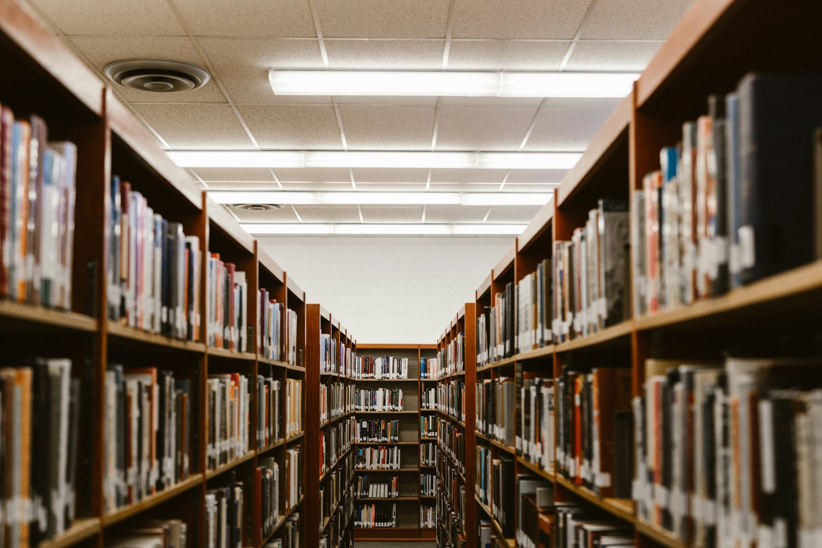 A university library aisle between tall bookshelves